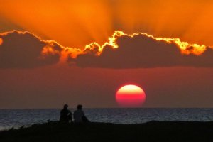 a person standing in front of a sunset
